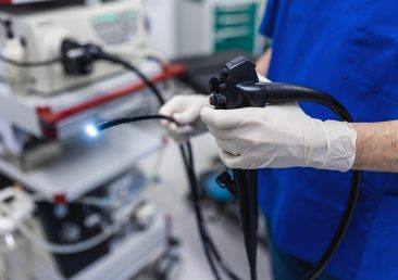 Doctor proctologist holding endoscope during colonoscopy. Probe colonoscope. Doctor gastroenterologist with probe to perform gastroscopy and colonoscopy