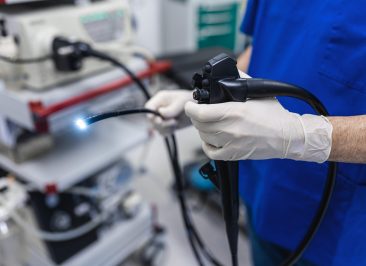 Doctor proctologist holding endoscope during colonoscopy. Probe colonoscope. Doctor gastroenterologist with probe to perform gastroscopy and colonoscopy