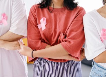 mulheres-segurando-as-maos-umas-das-outras-e-usando-fita-rosa-no-peito-conceito-de-apoio-de-solidariedade