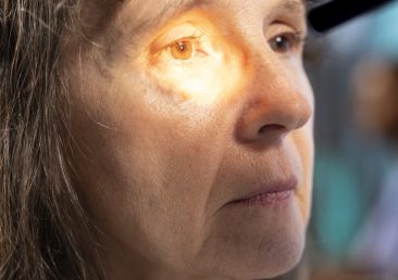 Optometrist examining eyesight with diagnostic tools for female patient. Experienced healthcare provider conducts vision test, consulting on eye care treatment and prescription options. Close up.