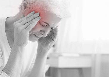 Senior woman having headache and touching her temples, suffering from migraine, free space