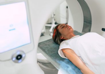 Young woman patient is ready to do magnetic resonance imaging in the modern hospital laboratory