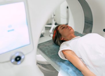 Young woman patient is ready to do magnetic resonance imaging in the modern hospital laboratory